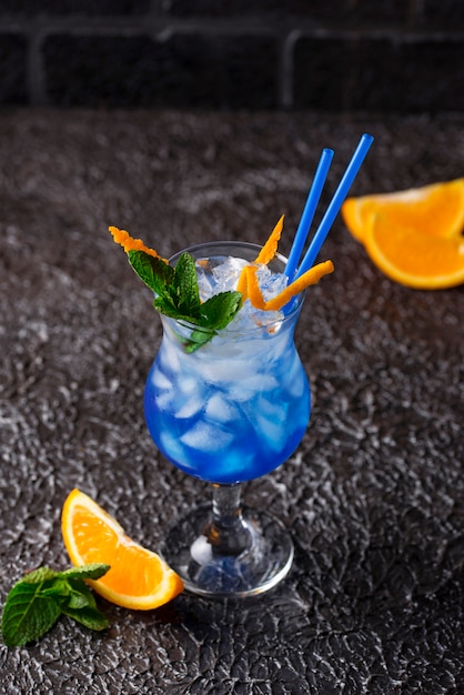 Bevanda blu del cocktail con ghiaccio e l'arancia