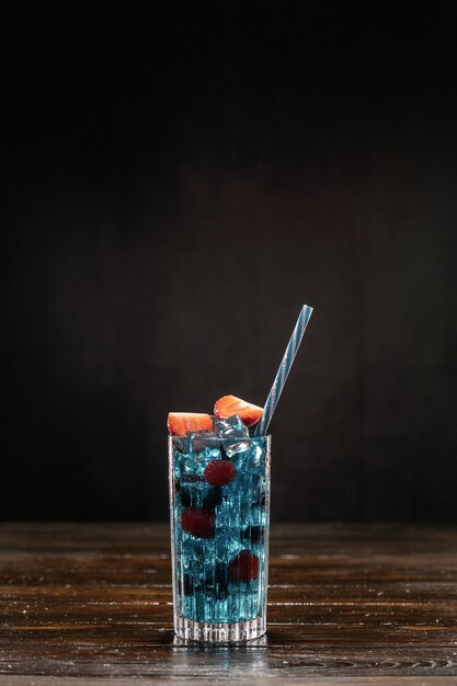 Blue cocktail and ice in a glass.