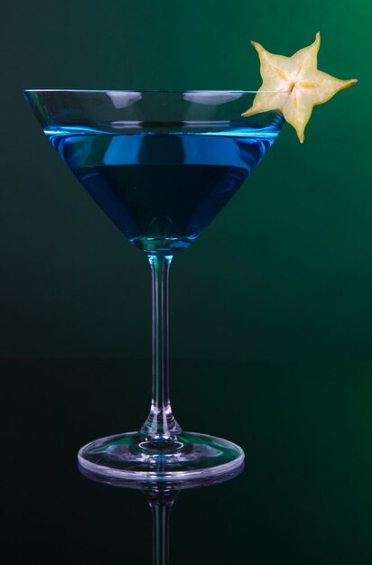 Фото Синий коктейль в бокале мартини на темно-зеленом фоне