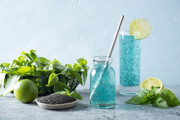 Blue cocktail with basil seeds and tropical juice in glass on light. Close up.