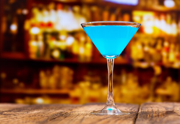 Blue cocktail on wooden table in a bar