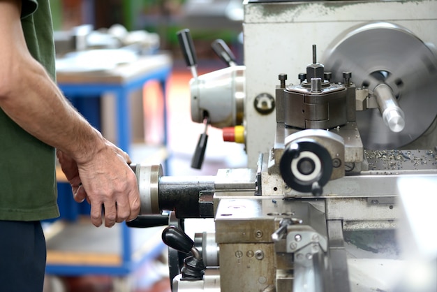 Operaio che fa lavoro manuale con un tornio