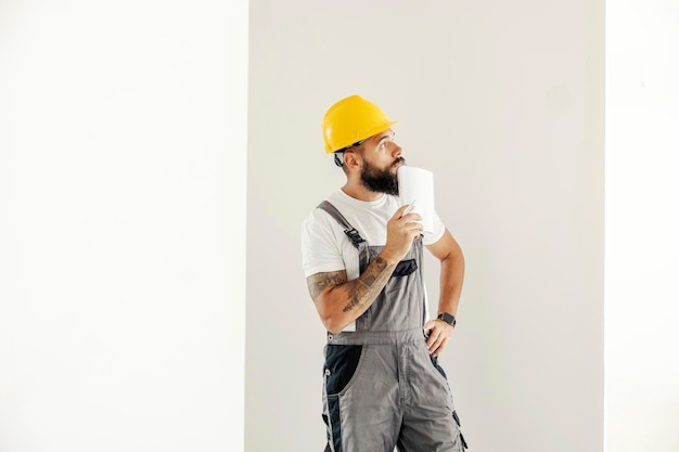 A blue collar worker standing in painted room and planning next step