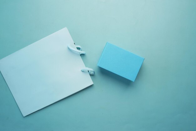 Blue color gift bag and box on table