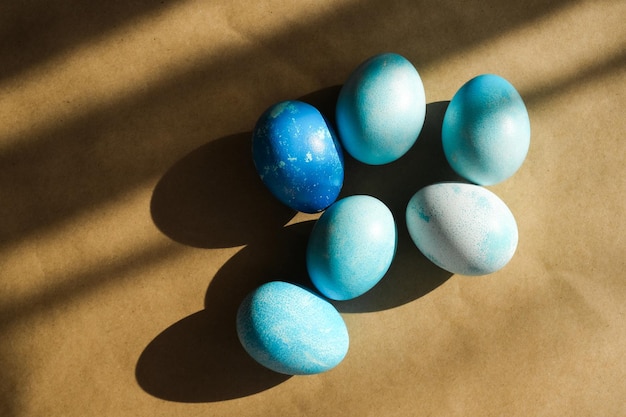 Blue coloured Easter eggs on minimal background with shadow play