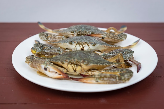 Blue crabs on plate, on a wooden background