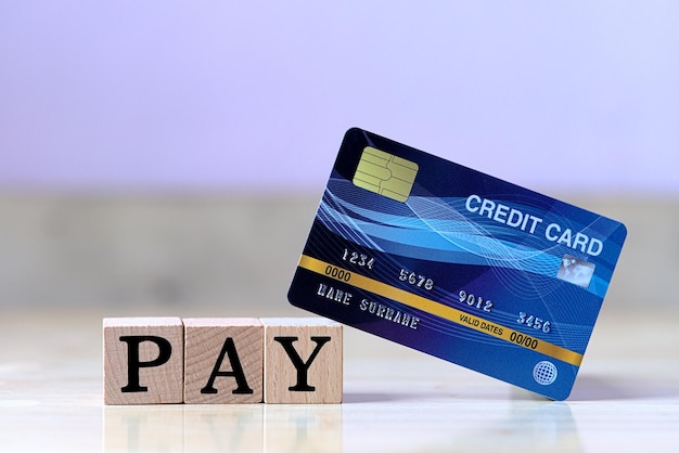 Blue credit card and wood cube letter put on wooden table