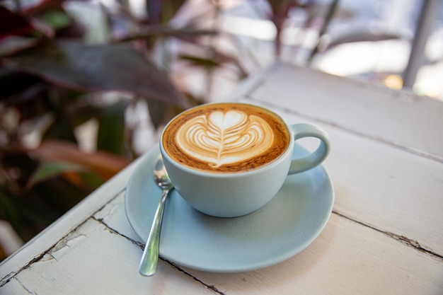 Blue cup of coffee on white rustic background with beautiful latte art