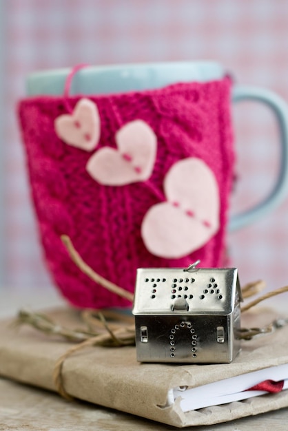 Blue cup in a pink sweater with felt hearts