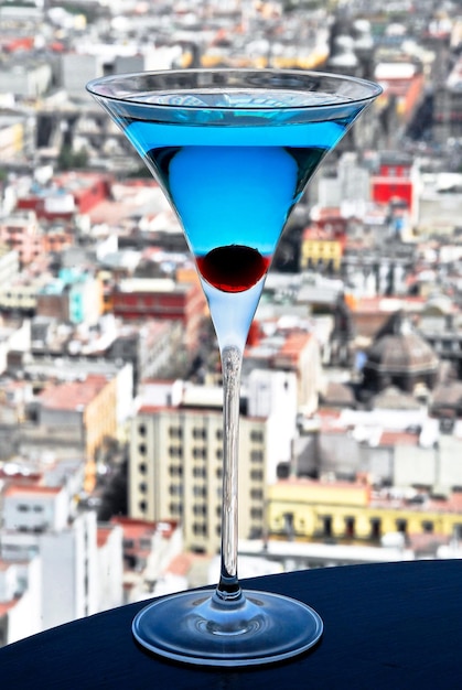 ブルー キュラソー マティーニ カクテル チェリー、街のパノラマ ビューの背景、ドリンク、ライフ スタイル
