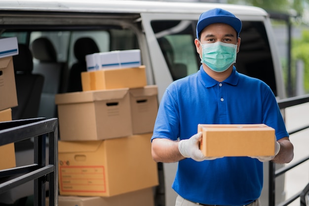 Blue Delivery asian man holding parcel cardboard box