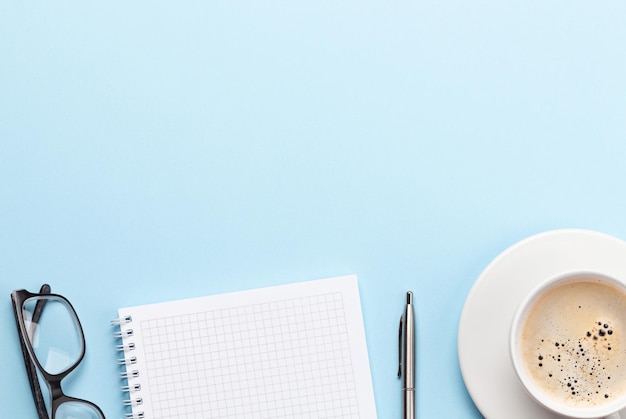 blue desk with supplies and coffee