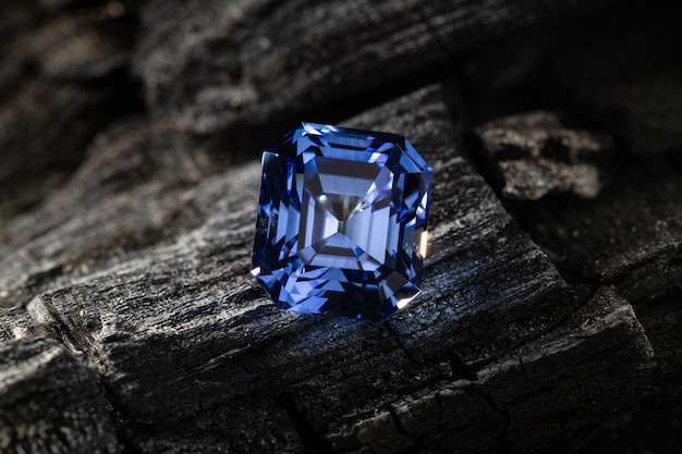 A blue diamond sits on a piece of wood.