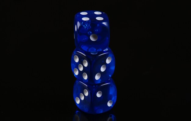 Blue dice on a black surface. Game addiction. Luck