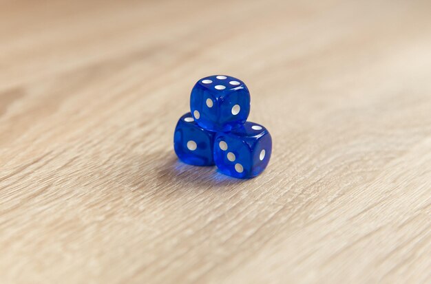 Photo blue dice on wooden table close up