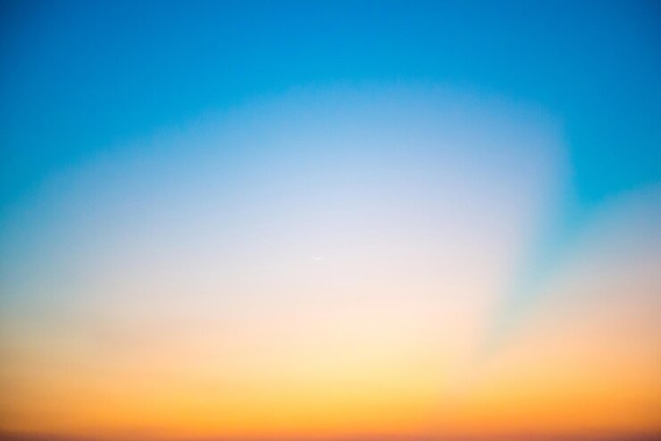 Blue dramatic sunset sky with golden rays of sun light. Can be used as nature background