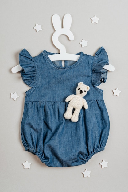 Blue dress on cute hanger with bunny ears and toy. Fashion newborn clothes   