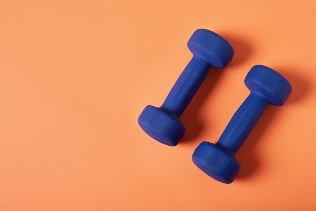 Blue dumbbells Isolated on orange background