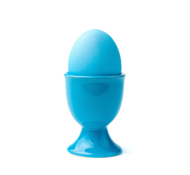 A blue Easter egg on a stand is isolated on a white background Side view closeup The concept of Easter