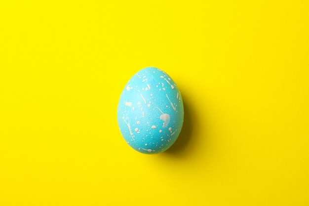 Blue Easter egg on yellow surface