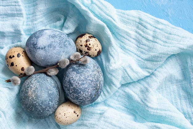 Blue Easter eggs on blue background. Naturally Eggs painted with hibiscus with marble stone effect. Eco paint.