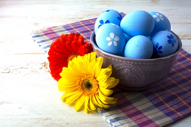 Blue Easter eggs in a bowl and gerbera