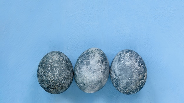 사진 파란색 배경에 파란색 부활절 달걀입니다. 자연적으로 대리석 돌 효과가있는 히비스커스로 칠한 계란. 에코 페인트.