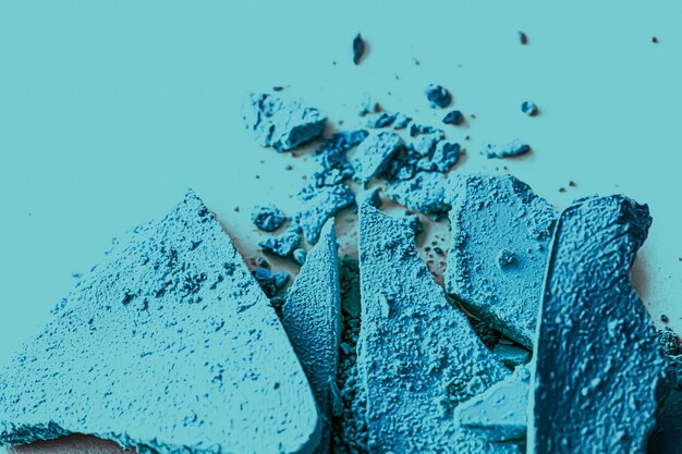 Foto polvere dell'ombretto blu come tavolozza di trucco primo piano cosmetici schiacciati e struttura di bellezza