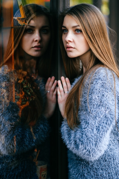 Foto ritratto stupefacente di auto-riflessione della giovane donna dagli occhi blu.