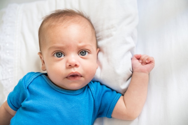 Blue eyed baby boy lying in crib