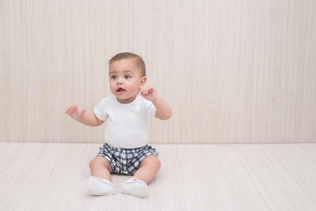 Blue-eyed baby boy on white wooden background