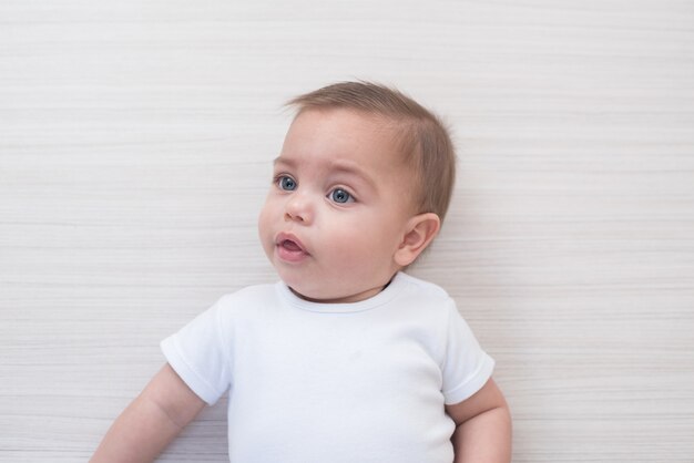 白い木製の背景に青い目の赤ちゃん