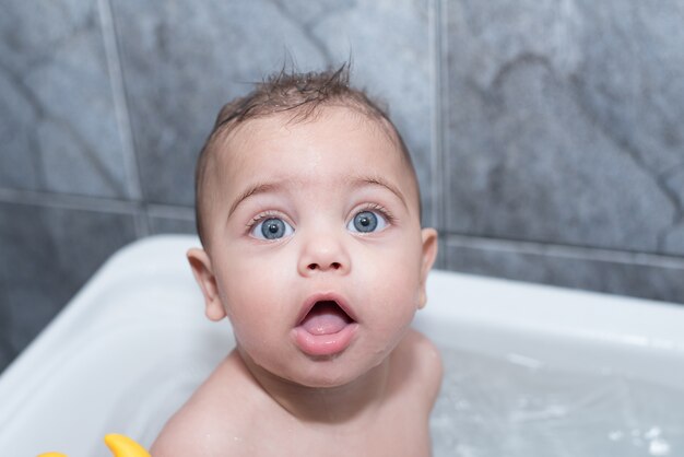 Blue-eyed boy bathing in bathtub