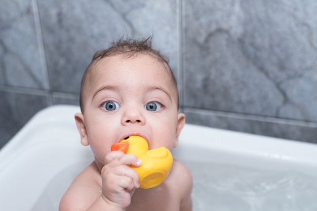 Blue-eyed boy bathing in bathtub