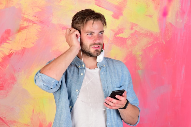 Blue eyed stylish hipster with smartphone Musical lifestyle