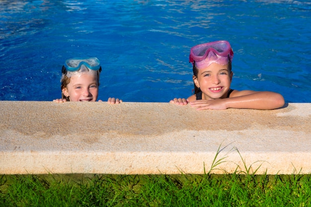 Blue eyes children girls on on blue pool poolside smiling