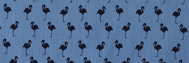 Синяя ткань с рисунком черного фламинго, подготовленная к продаже в текстильном магазине высокого качества