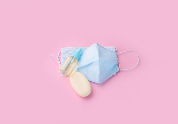 Photo blue face mask with soap and hand antiseptic on a light background. protection from the virus.