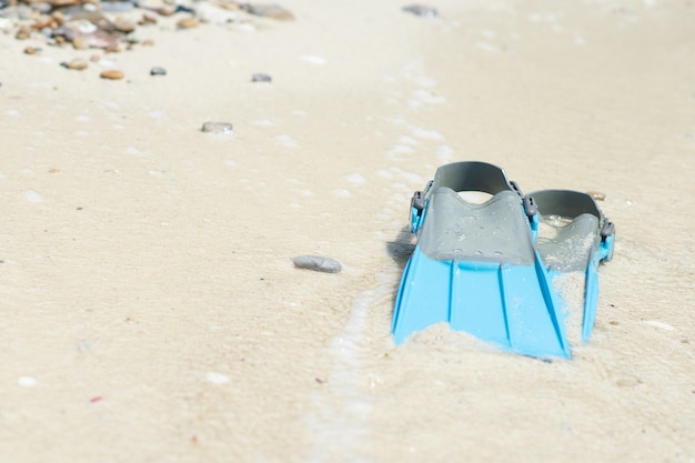 Blue fins for snorkel on the beach at the sea.