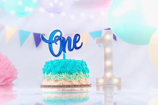 밀크쉐이크 케이크를 위한 파란색 첫 번째 생일 케이크 파란색 풍선과 조명이 있는 숫자 1로 장식된 소년을 위한 첫 번째 생일 장식