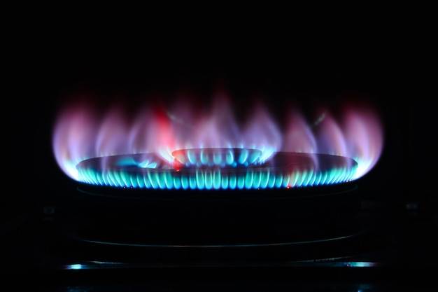 Photo the blue flame of a cooker burner in the dark