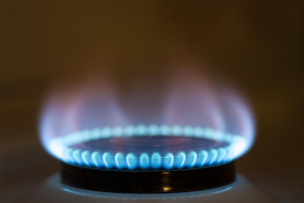 Blue flame of gas on a stove with blurred background