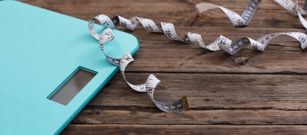 blue floor scales and tape on dark wooden background