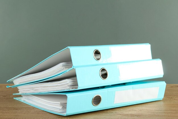 Blue folders on wooden table on grey background