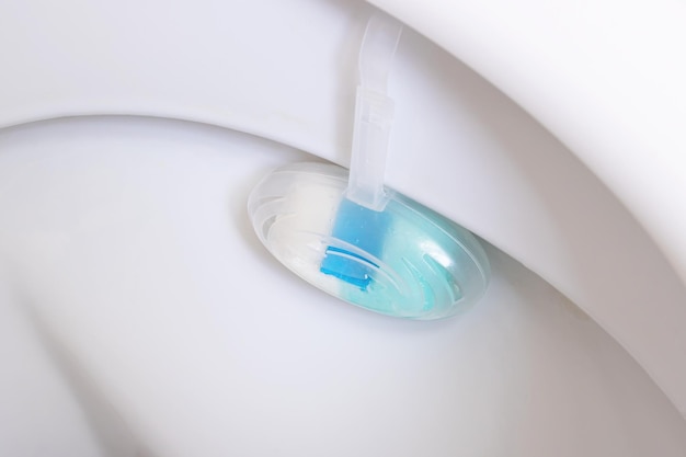 Blue freshener on a white toilet closeup