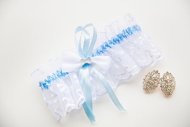 Blue garter of the bride and her beautiful wedding jewelry