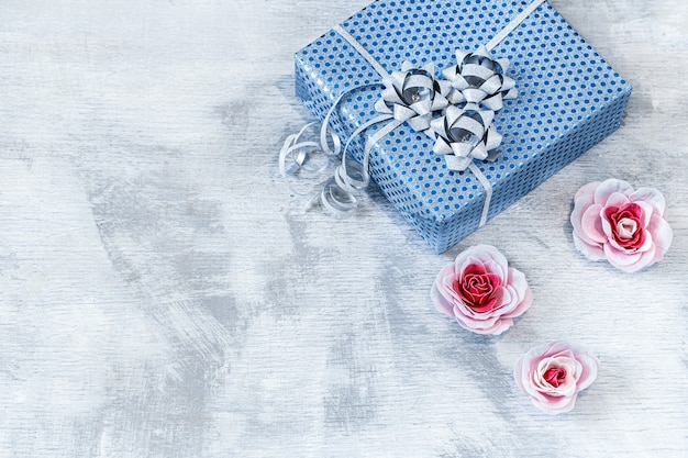 Blue gift box on a light wooden background.