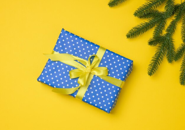 Blue gift box tied with ribbon on a gray background top view festive backdrop