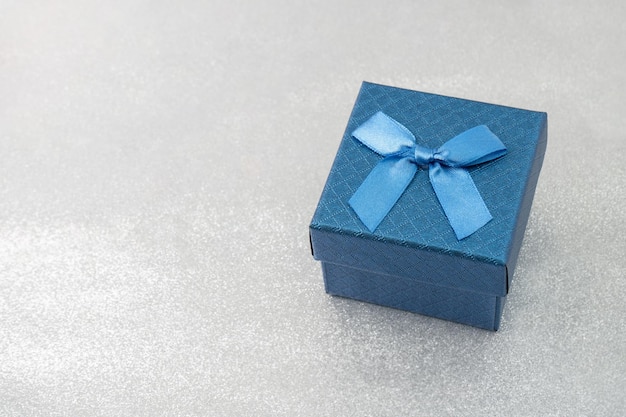 Blue gift box with bow on sparkle background