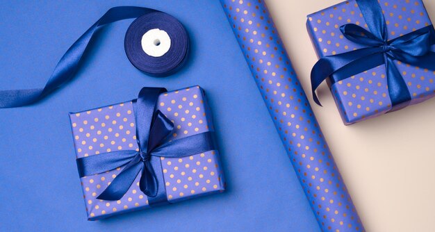 blue gift box wrapped in silk ribbon on a bluee background top view